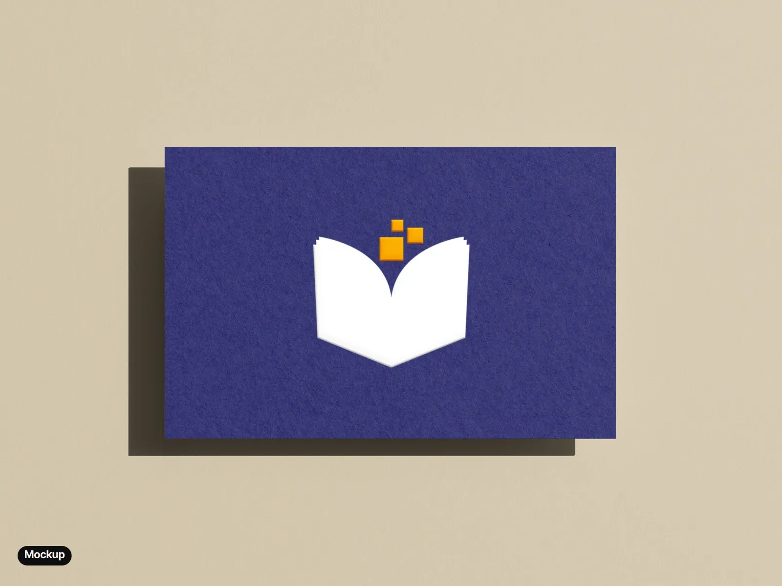 Mockup: an indigo business card on a beige ground, the white book and amber pixels printed and embossed.