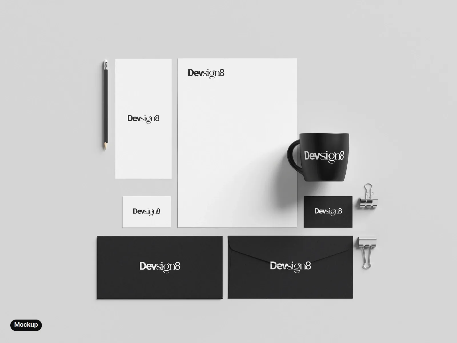 Mockup: a stationery set from above: a letterhead, a DL card and a white business card with the black wordmark; a black business card, two black envelopes and a black mug with the white wordmark.