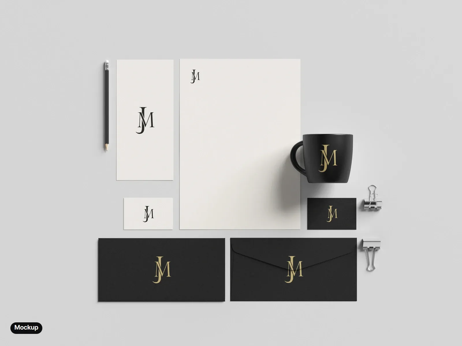 Mockup: a stationery set from above: a cream letterhead, a DL card and a cream business card with the black monogram; a black business card, two black envelopes and a black mug with the gold monogram.